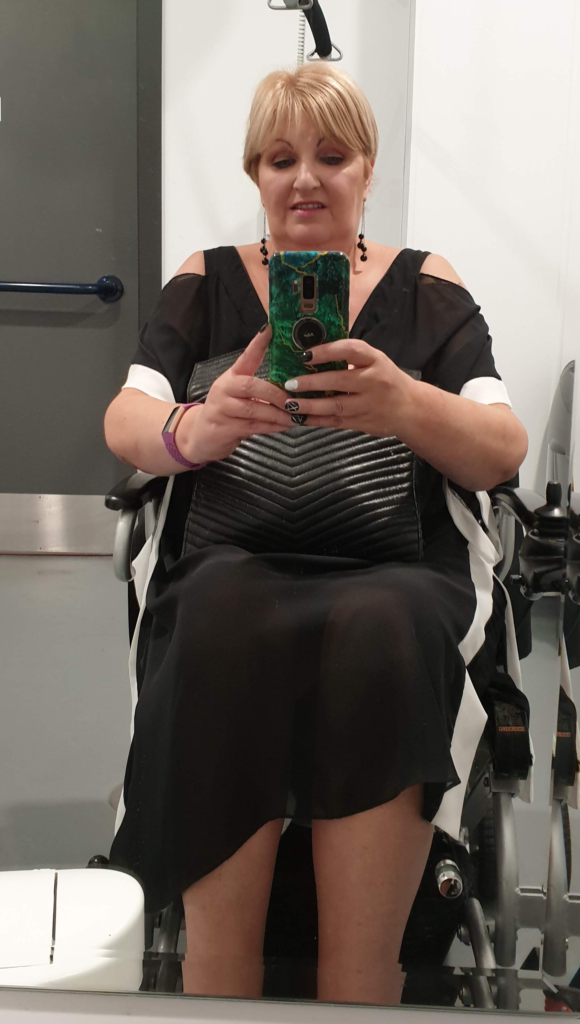 Rachael sat in her electric wheelchair with a black dress and balck shoes