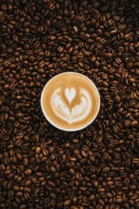 Coffee cup stood on coffee beans