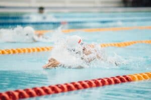Photo of a person swimming in a swimming pool with lanes marked out